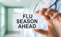 doctor holding card that says flu season ahead